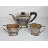 A George V silver Art Deco three piece tea set of teapot, cream jug and sugar bowl, rectangular form