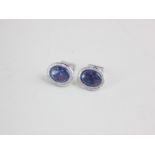 A pair of black opal and diamond cufflinks the oval cabochons in diamond set border in 18ct white