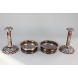 A pair of silver plated bottle coasters, and a pair of silver plated column candlesticks with
