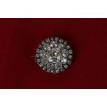 An old cut diamond cluster brooch with a central cushion shaped stone within a two row border of