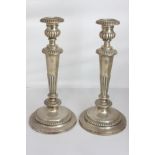 A pair of George III silver candlesticks with campana shaped sconces and drip pans on tapered demi-