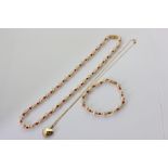 A 9ct gold heart locket on a curb link neckchain 3.1g, an imitation pearl and coral necklace and