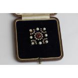 A diamond and pearl brooch lozenge shape set with a central cushion cut stone within graduated old