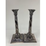 A pair of silver plated Corinthian column candlesticks, with embossed swag design, (plate worn) 34cm
