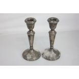 A pair of modern silver candlesticks vase sconces on tapered stems and loaded circular bases,