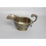 A George VI silver sauce boat with flying scroll handle and gadrooned rim, maker S Blanckensee,