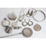 A group of silver items including bangles and brooches, a vesta case, two US coin pendants, and an