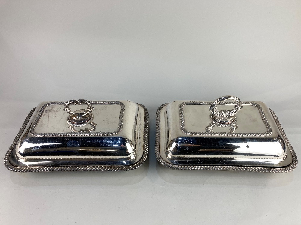 A matched pair of silver plated rectangular tureens and covers, with gadroon border and scrolling