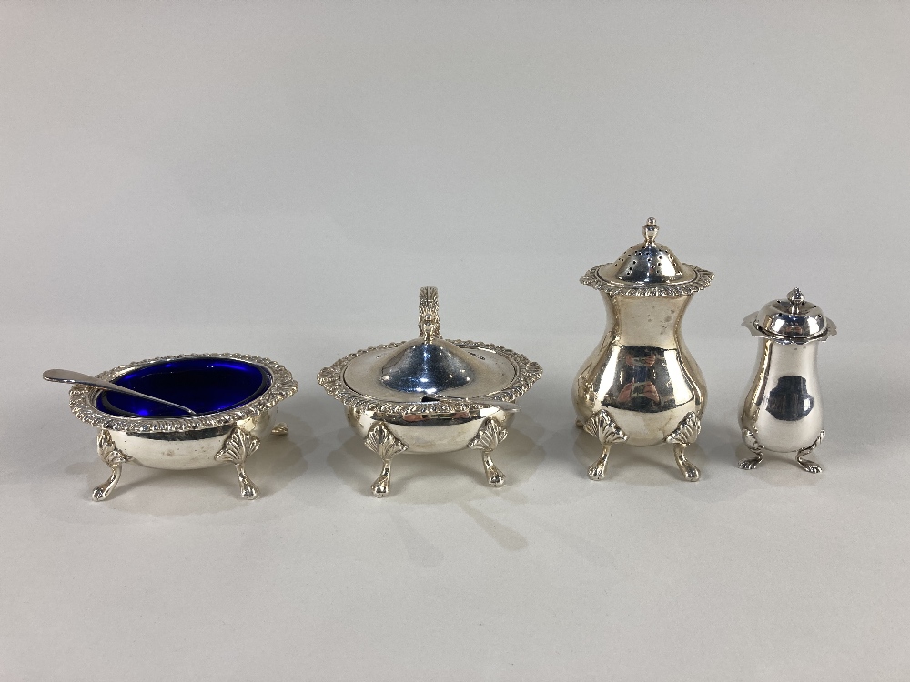 An Elizabeth II silver three piece cruet set, maker E J Houlston, Birmingham 1965, with blue glass