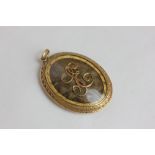 An 18ct gold memorial locket with hair reserve and applied initials