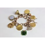 A gold charm bracelet hung with various pendants including a spade guinea and hardstone seals 79.