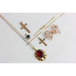 A 9ct gold box link chain with sapphire pendant, a red stone pendant on chain, two gold crosses, and