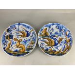A pair of tin glazed pottery chargers, one decorated with a scene of a hare and a bird by a tree,
