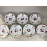 A set of seven Berlin KPM porcelain dessert plates, decorated with floral sprays and gilt borders on