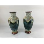 A pair of Royal Doulton baluster vases, with overlaid grapevine swag design, on mottled green