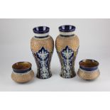 A pair of Royal Doulton Lambeth stoneware baluster vases, decorated in light relief with panels of