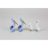 A pair of Herend porcelain models of pelicans, with blue fishnet bodies and gilt beaks, 8cm high,