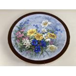 A Meissen porcelain wall plate, hand painted with flowers, scored through crossed swords mark to