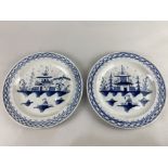 A pair of 18th / 19th century blue and white plates in the Chinese style, depicting a dwelling by