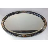 An oval wall mirror with Chinoiserie decorated black lacquered frame, and gilt embellishments,