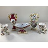 A pair of porcelain floral encrusted cornucopia vases, a porcelain vase with scroll handles and