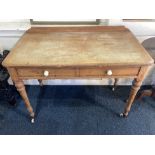 A Victorian stripped pine rectangular side table with raised back, two drawers with white ceramic