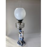 A blue and white porcelain figural oil lamp, with white glass shade and clear glass well, the base