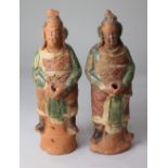 Two similar Chinese earthenware figures, possibly Sung Dynasty, both partially glazed in green,