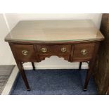 A mahogany bowfronted side table / lowboy with three drawers and brass ring drop handles, fret cut