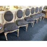 A set of six distressed white painted dining chairs with upholstered oval backs and seats on