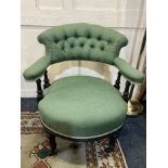 A 19th century green upholstered button back tub chair with turned supports and legs on castors