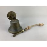 A large brass bell with wall mount, clapper and pull 17cm high