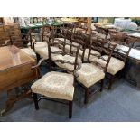A set of ten Chippendale style ladderback dining chairs, including two carvers, with serpentine