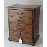 A miniature oak chest of four graduated drawers, with brass swing handles, on flattened bun feet,