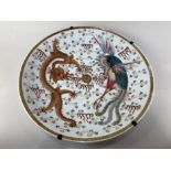 A Chinese porcelain charger, depicting a dragon and a ho-ho bird chasing a flaming pearl, with