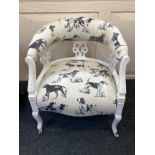 A white painted tub chair, upholstered in cream fabric printed with different dogs, the supports
