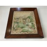 An early 19th century framed needlework of a country house with plants and trees in the