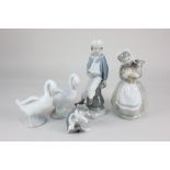 A Lladro porcelain figure of a boy holding a sailing boat, 23cm high, and a Lladro model of a kitten