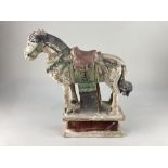 A Chinese pottery partially glazed model of a horse, possibly Ming Dynasty, on integral