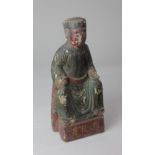 A Chinese wooden shrine figure, possibly Ming Dynasty, with polychrome painted decoration, 23.5cm