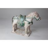 A Chinese pottery partially glazed model of a horse, possibly Han Dynasty, decorated with green