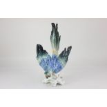 A Karl Ens porcelain model of a parrot, with blue, green and yellow feathers, 35.5cm high