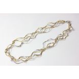 A silver and silver gilt necklace of curved wire links, bolt ring clasp, by Joanne Thompson,