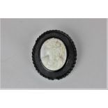 A Victorian shell cameo brooch in a carved jet mount