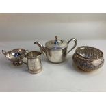 An Indian white metal three piece bachelors tea set, with engraved scrolling border and scroll