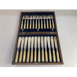 An oak cased set of twelve silver plated and white handled fish knives and forks