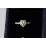 A heart cut diamond ring the centre stone in a brilliant cut border and with six stones to each