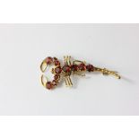 A gold mounted garnet scorpion brooch claw set with mixed cut stones