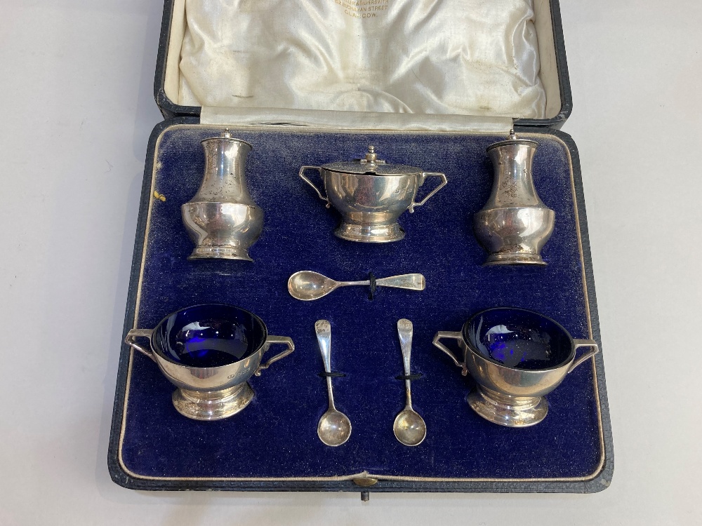 A cased George V silver five piece cruet set, maker Josiah Williams & Co, London 1928, with blue