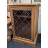 A pine cabinet with lead glazed panel door enclosing a shelf, on plinth base, 54cm